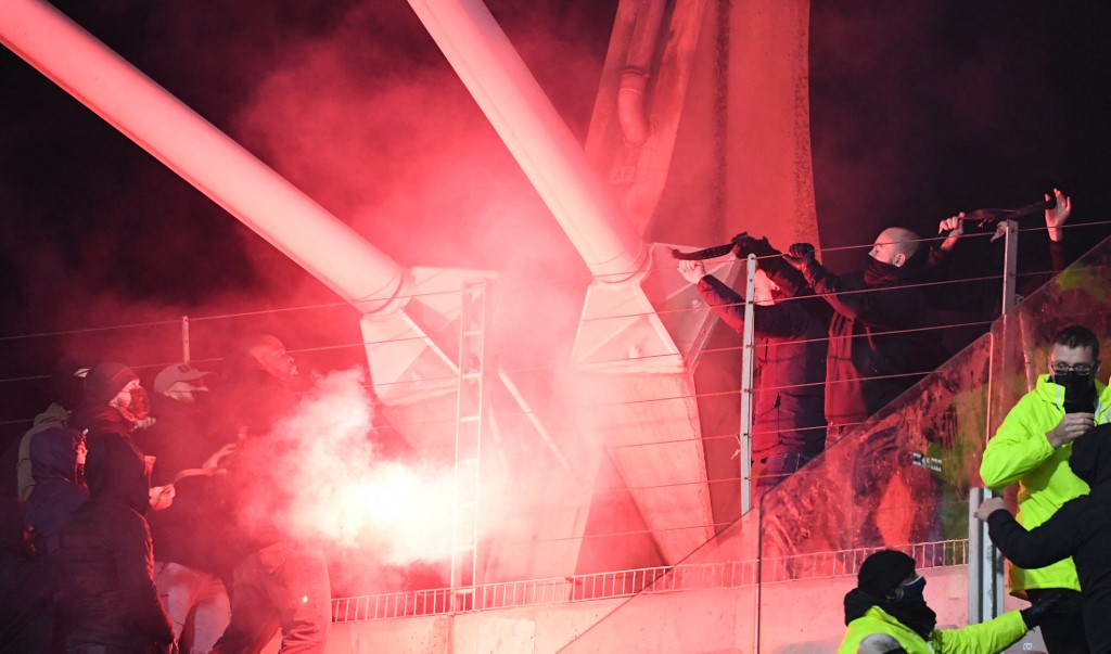 Des supporters craquant des fumigènes lors de Paris FC - OL (Photo by Bertrand GUAY / AFP)